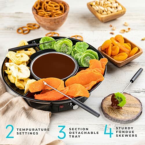 Chocolate fondue set with dried fruits, pretzels, and nuts.