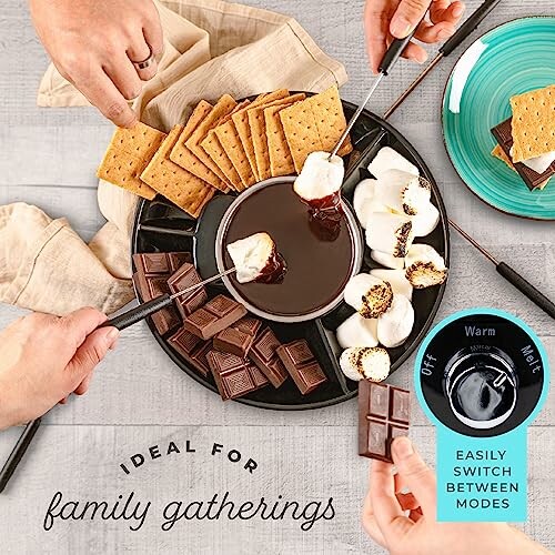 Hands dipping marshmallows into chocolate fondue with graham crackers and chocolate pieces.
